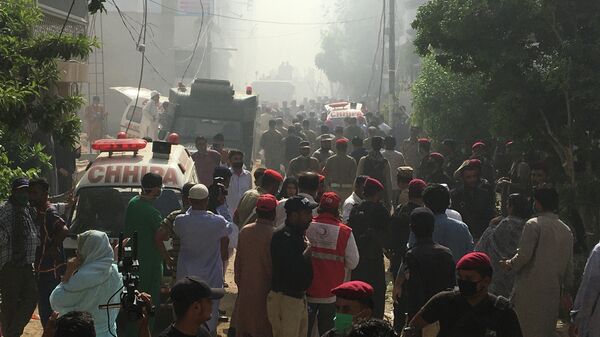 Машины скорой помощи на месте крушения пассажирского самолета в жилом районе недалеко от аэропорта в Карачи