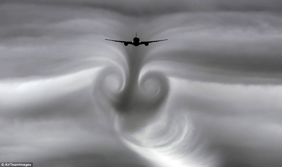 The cloud vapours spin around the vortex trail left by the plane, creating this twister effect behind it