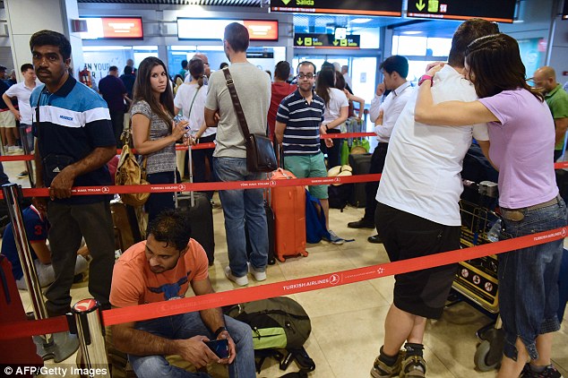 People wait at Turkish Airlines desk at Adolfo Suarez airport in Barajas, near Madrid on Saturday as Turkish Airlines cancelled their flights following last night