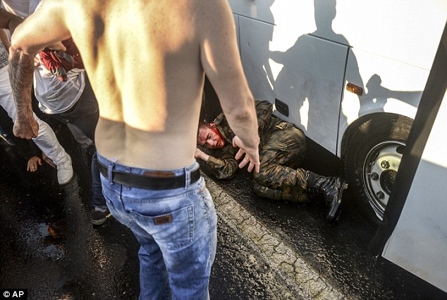 People kick and beat a Turkish soldier that participated in the attempted coup, on Istanbul